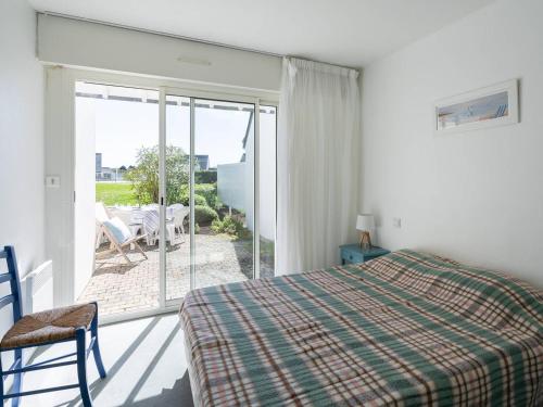 une chambre avec un lit et une porte coulissante en verre dans l'établissement Appartement 3P à Carnac avec Piscine Chauffée - Proche Plage et Thalasso - FR-1-477-102, à Carnac