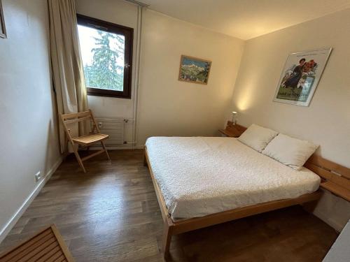 a bedroom with a bed and a window and a chair at Appartement Megève, 2 pièces, 6 personnes - FR-1-597-7 in Megève