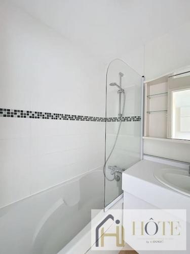 une salle de bain blanche avec une douche et un lavabo dans l'établissement Horizon Marin - Vue Mer & Confort au 4e Étage, à Bray-Dunes