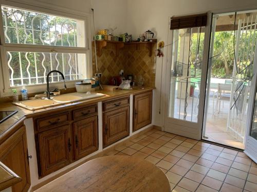 une cuisine avec un évier et une porte coulissante en verre dans l'établissement Villa à Hyères avec piscine, climatisation et Wi-Fi, à 5 min de la plage - FR-1-335-169, à Hyères