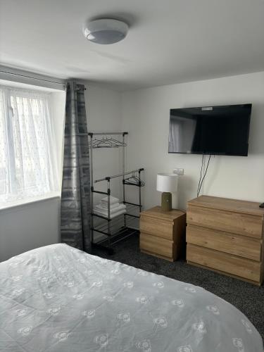 a bedroom with a bed and a flat screen tv at Duke of Albany in Weymouth
