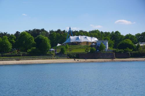 a large tent on the beach next to the water at Seeliebe mit Sauna und nur 50 mtr. bis zum Strand in Senftenberg