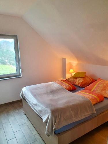 a bedroom with a large bed with a window at Ferienhaus Seeblick in Wisełka
