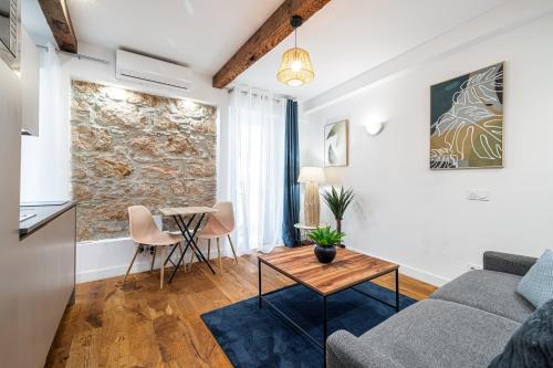 un salon avec un canapé et une table dans l'établissement Pretty & Quiet Studio in Port Area, à Nice