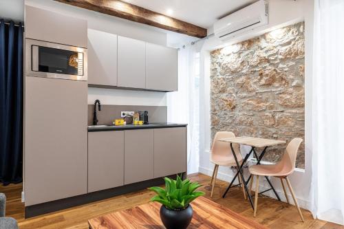 une cuisine avec des armoires blanches et une table et des chaises dans l'établissement Pretty & Quiet Studio in Port Area, à Nice