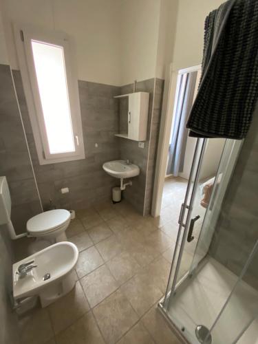 łazienka z 2 toaletami, umywalką i prysznicem w obiekcie Affittacamere Da Pippi w mieście Castel San Pietro Terme