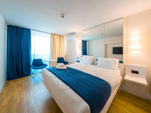 a hotel room with a large bed and two chairs at Amazing view apartments in Batumi