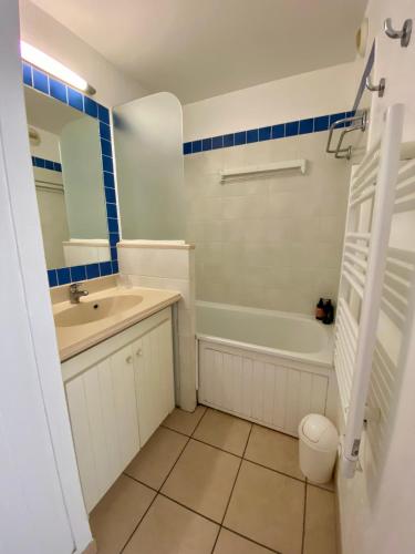 une salle de bain avec un lavabo, une baignoire et des toilettes dans l'établissement Logement au bord de l'océan avec piscine, à Lacanau-Océan