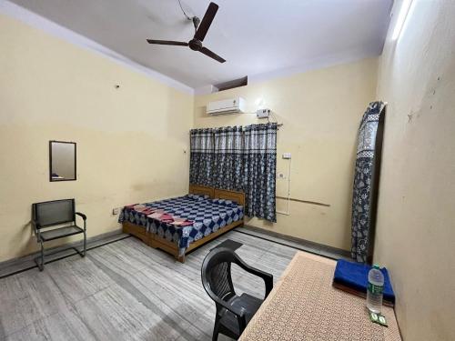 a room with a bed and a table and chairs at Vishwa Deva Homestay in Varanasi