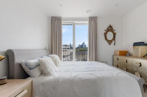 倫敦的住宿－Modern New 1-Bedroom Home Stunning Views，一间卧室设有一张床和一个大窗户