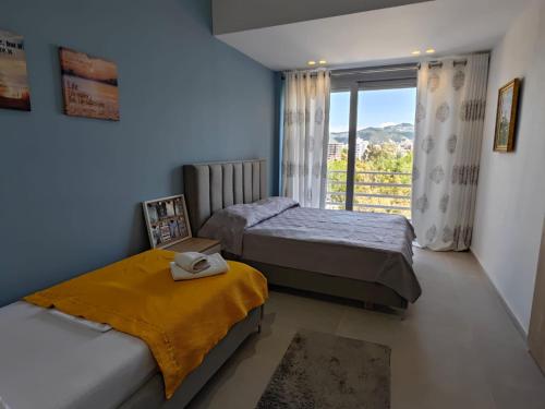 een slaapkamer met 2 bedden en een raam met uitzicht bij Best View Apartment in Vlorë