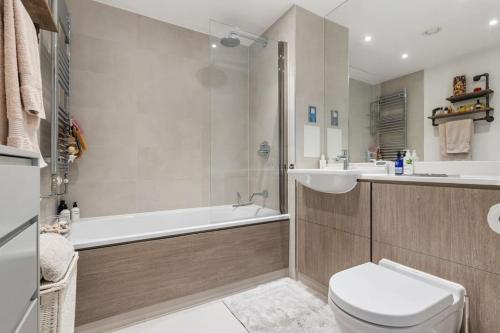 倫敦的住宿－Modern New 1-Bedroom Home Stunning Views，带浴缸、卫生间和盥洗盆的浴室