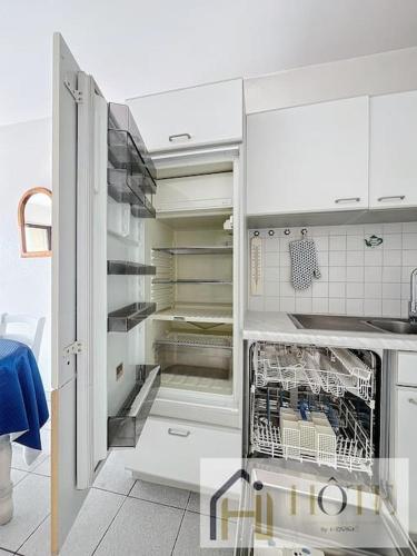 une cuisine avec un réfrigérateur vide et une porte ouverte dans l'établissement Balcon des Dunes - Vue Mer, Confort - Parking, à Bray-Dunes