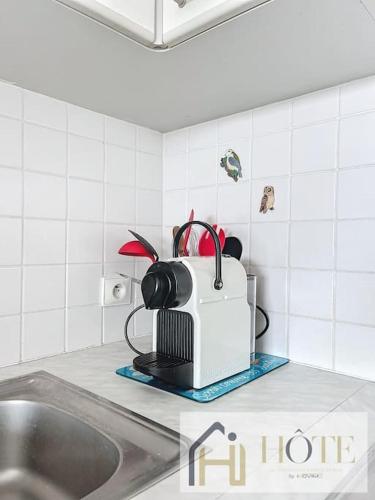 Un grille-pain est installé sur un comptoir de cuisine à côté d'un évier. dans l'établissement Balcon des Dunes - Vue Mer, Confort - Parking, à Bray-Dunes