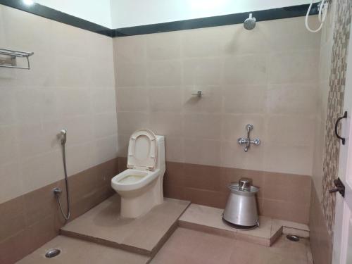 a bathroom with a toilet with the lid up at Chill Breeze Castle - 4BHK Villa with Captivating city view & Mountain view, Wifi, Campfire, Homemade Food in Kodaikānāl