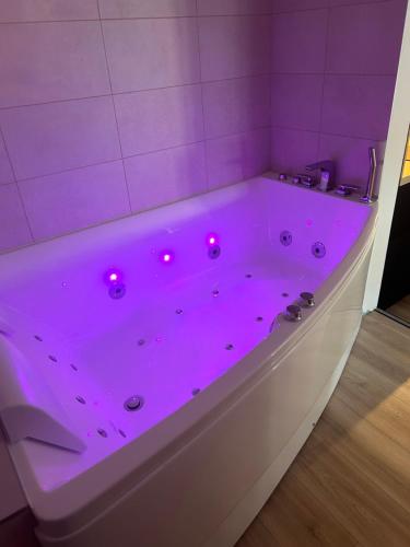 une baignoire violette avec des lumières rouges à l'intérieur dans l'établissement La suite Tournonaise, à Tournon-sur-Rhône