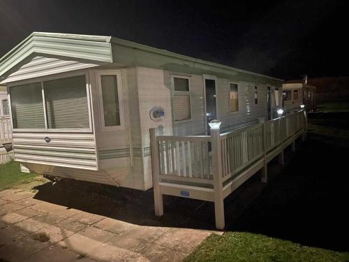 a mobile home with a porch at night at Dans van in Chapel Saint Leonards