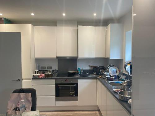 a kitchen with white cabinets and a counter top at Serene Stay Sanctuary in Romford