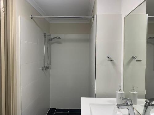a bathroom with a shower and a sink at Broadway Central Apartment in Sydney