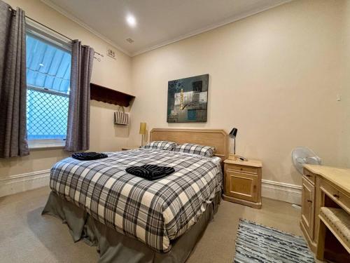 ein Schlafzimmer mit Bett, Schreibtisch und Fenster in der Unterkunft Subiaco Heritage House "gem"! in Perth