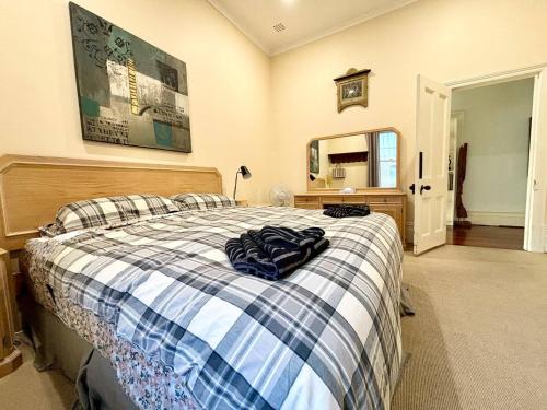 ein Schlafzimmer mit einem Bett mit einer blau-weißen Decke in der Unterkunft Subiaco Heritage House "gem"! in Perth