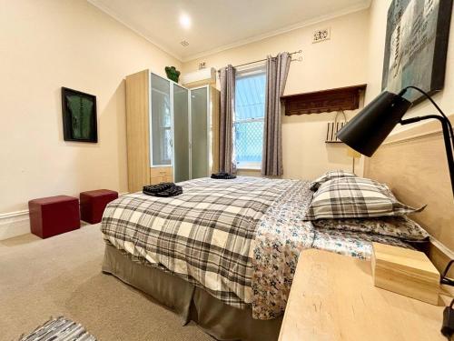 um quarto com uma cama e um candeeiro em Subiaco Heritage House "gem" em Perth