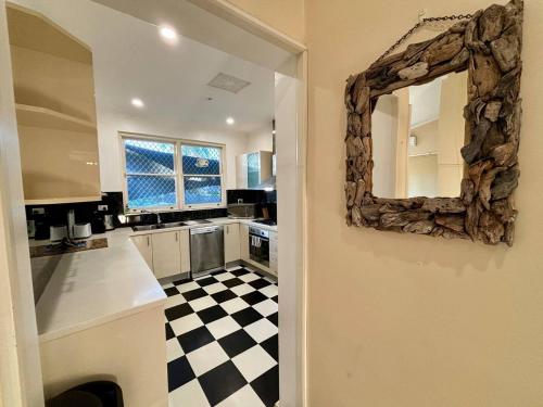 uma cozinha com um espelho e um piso xadrez em Subiaco Heritage House "gem" em Perth