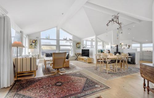a living room with a table and a dining room at 4 Bedroom Beautiful Home In Løkken in Løkken