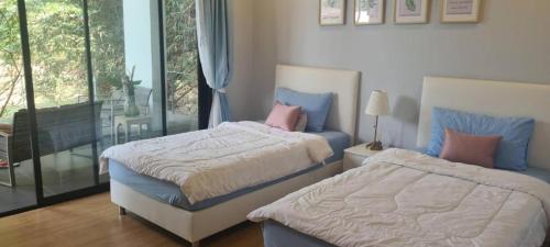 1 dormitorio con 2 camas y ventana en สวนภาคินรัตน์ 