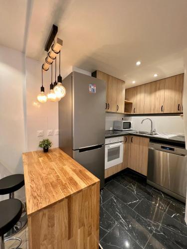 une cuisine avec un réfrigérateur en acier inoxydable et des armoires en bois dans l'établissement La Résidence Panthéonique, à Paris