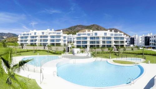 a large swimming pool in front of a large building at Mara's Apartments Higuerón West - Luxurious & Sunny in Fuengirola