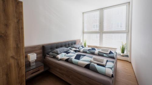 a bed in a room with a large window at Spirit apartments Brno, with parking in Brno