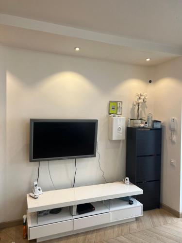 un salon avec une télévision à écran plat sur un mur dans l'établissement La Résidence Panthéonique, à Paris