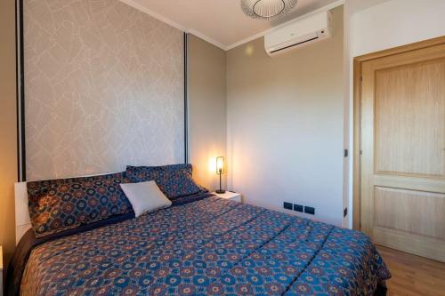 1 dormitorio con 1 cama con edredón azul en [A 15 min dal Vaticano]Attico Silenzioso, Elegante en Roma
