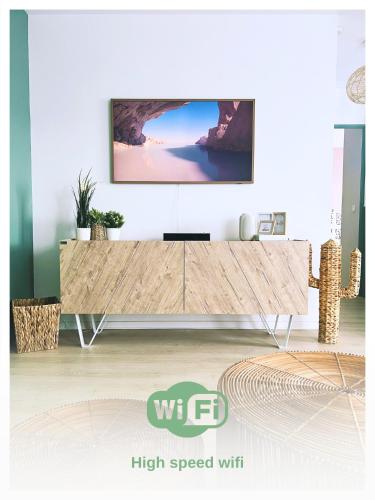 un salon avec une télévision sur un mur dans l'établissement L'Organik Disney 7 min Gare 5 min parking privé, à Chessy