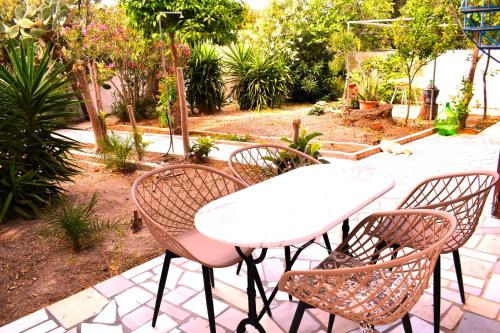 a white table and four chairs in a garden at Gianna Seaside in Koutsounari