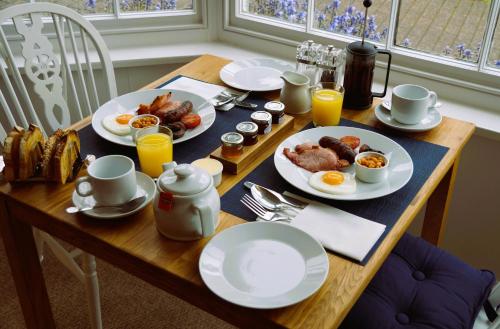 a table with plates of breakfast food on it at Radcliffe Guest House in Ross on Wye