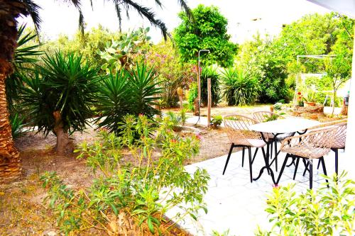 a patio with a table and chairs in a garden at Gianna Seaside in Koutsounari