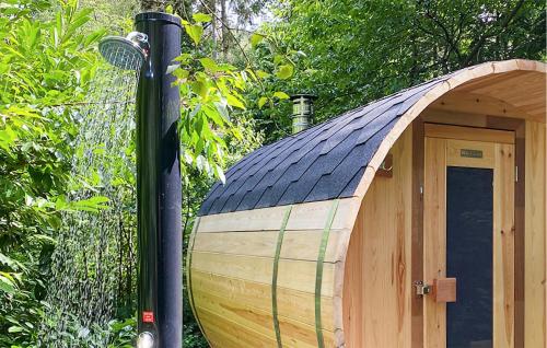 a wooden boat with a black roof next to a pole at Awesome Home In Rheezerveen With Sauna in Rheezerveen