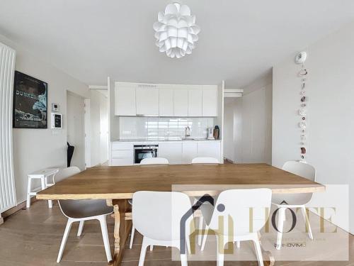 une cuisine et une salle à manger avec une table et des chaises en bois dans l'établissement Zuydcoote Charme, Balcon vue Mer, Confort, à Zuydcoote
