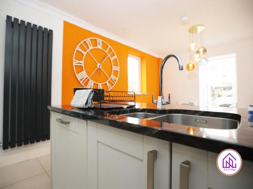 una cocina con un reloj grande en la pared en Victoria House,5 Bed, Fantastic Location, Free Parking, Contractors en Cardiff