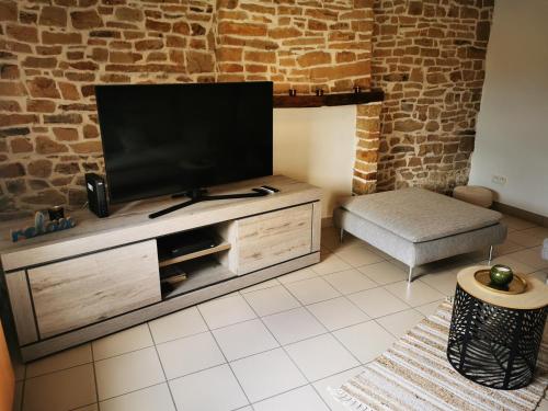 een woonkamer met een flatscreen-tv op een entertainmentcentrum bij Les 4 Arbres in Profondeville