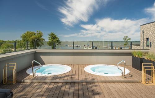 two hot tubs on the deck of a building at Lovely Home In Lembruchdümmer See in Lembruch