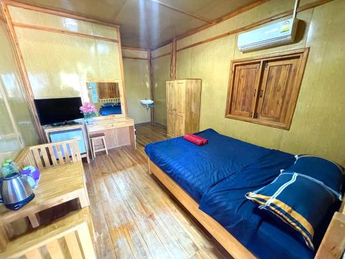 una camera con letto blu e televisore di จันทวี รีสอร์ท a Changwat Prachuap Khiri Khan