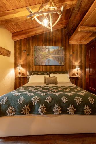 a bedroom with a large bed and wooden walls at Elva Apartments in Elva