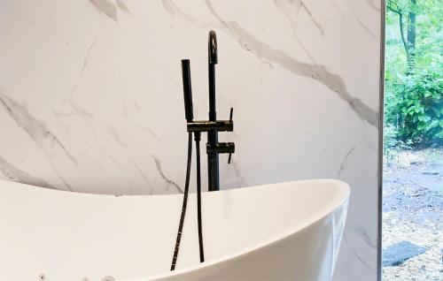 a bathtub in a bathroom with a marble wall at Stunning Home In Rheezerveen With Wifi in Rheezerveen