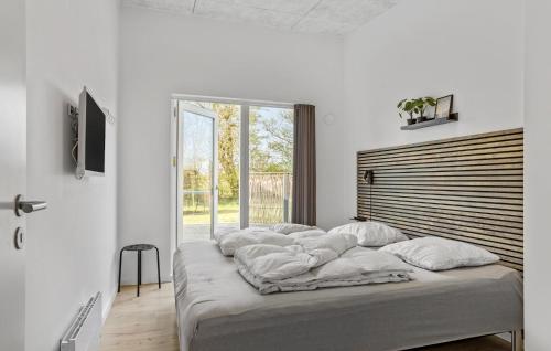 KnudにあるBeautiful Home In Haderslev With 4 Bedrooms And Wifiの白いベッドルーム(白い枕付きのベッド1台付)