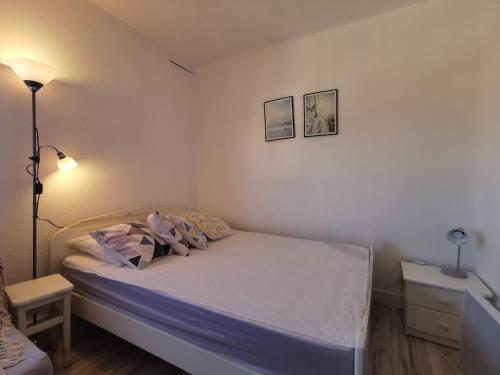 - une petite chambre avec un lit et une lampe dans l'établissement Soleil Levant 2 - En bord de mer - Superbe Appartement Cosy - Accès direct plage - Proche Commerces et Animations, au Barcarès