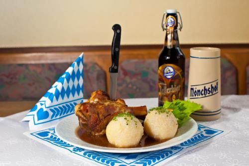 une assiette de nourriture et une bouteille de bière sur une table dans l'établissement Landgasthof Am Sonnenhang, à Vohenstrauß