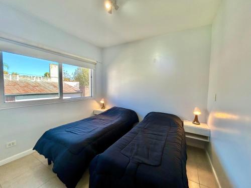 a bedroom with two beds and a window at Terrazas del río Tigre. in Tigre